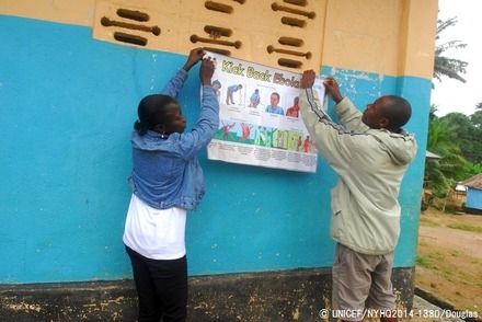 カイラフンで、エボラの症状や予防法が描かれたポスターを壁に貼るスタッフ