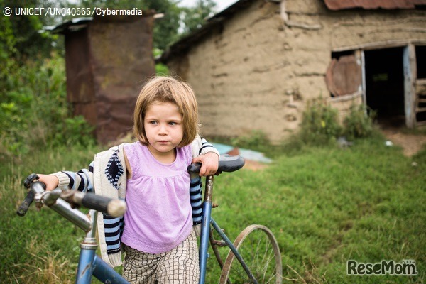 タイヤのない古い自転車で遊ぶ4歳の女の子 （ルーマニア）2016年8月撮影　(c) UNICEF_UN040565_Cybermedia