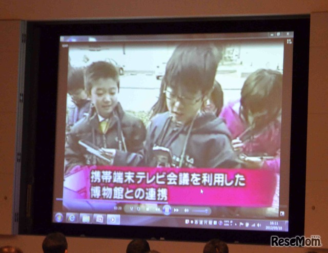 携帯のテレビ会議機能使い、博物館の研究員に質問をしている小学生を紹介