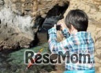 海で撮影を行うこども（イメージ）