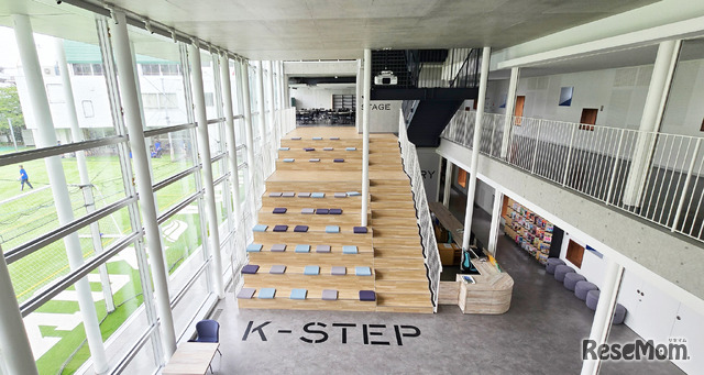 K-Placeは「WINGS探究」の象徴的な場所。開放的な吹き抜けの階段「K-STEP」に座り、生徒たちがさまざまな学びを深める