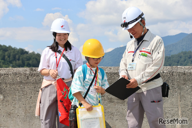 天端を歩きながら発電所について質問。「この下に発電所がある！」と地下発電所に興味津々