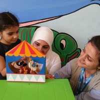ユニセフ教育専門官とともに、ユニセフのECDキットに含まれている指人形を使って遊ぶ、シリアの女の子（5歳） (c) UNICEF_UNI176330_Youngmeyer