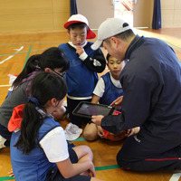 2018年1月26日、佐賀県多久市立東原庠舎中央小学校で行われた公開授業のようす（写真は体育の時間）シュートとパスの回数を記録しておき、試合後の作戦会議に役立てる。先生はアドバイス係