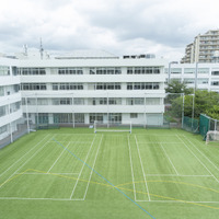 芝生のグラウンドを取り囲むように同じ敷地内に幼稚園、高校、中学校がある