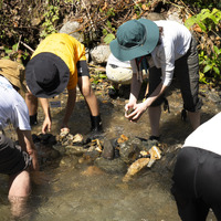 地道に石を集めて積みながら、水の流れをつくる