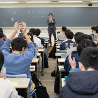 合格を一緒に祝う功刀氏と本郷校の生徒たち