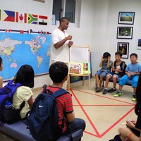【パジュ英語村】世界地図を前に各国の特徴を英語で説明し、首都を言い当てるクイズをしている子どもたち