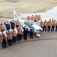 軽量飛行機を囲んで記念撮影するテクノアカデミーの学生と室屋義秀選手