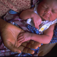 お母さんの腕の中で眠る生まれたばかりの赤ちゃん（ガーナ）